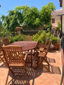 een houten tafel en stoelen op een patio bij The Knights Courtyard in Rhodos-stad