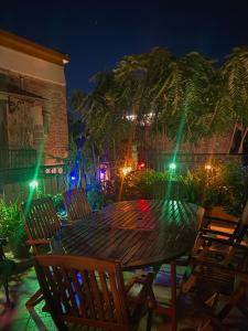 einen Holztisch und Stühle auf einer Terrasse in der Nacht in der Unterkunft The Knights Courtyard in Rhodos (Stadt)