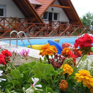 a garden of flowers in front of a swimming pool at HolidaySport Haus in Balatongyörök
