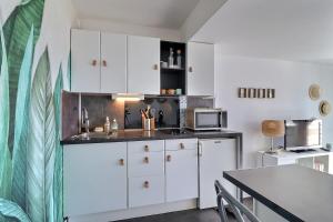 a kitchen with white cabinets and a table at Cosy Deauville in Deauville