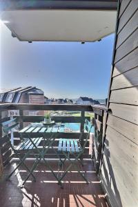 a patio with a table and chairs on a balcony at Cosy Deauville in Deauville