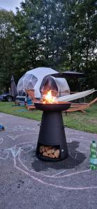 a fire pit with a tent in the background at Friesland Glamping Camp Schortens in Schortens