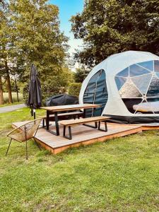 una tienda y una mesa de picnic y una silla en el césped en Friesland Glamping Camp Schortens en Schortens