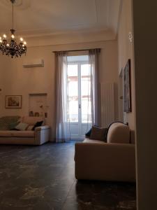 - un salon avec deux canapés et une grande fenêtre dans l'établissement Casa Gaia, à Naples