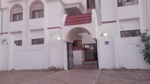 uma entrada para um edifício branco com uma porta em arco em VictoriaS em Al Ain