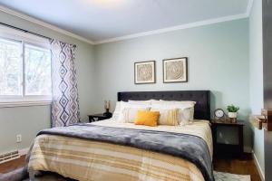 a bedroom with a large bed with orange pillows at Book Entire House, 3 Bedrooms in White Bear Lake in Saint Paul