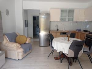 a kitchen with a table and a kitchen with a refrigerator at Apartman Mimi in Matulji +3 photos