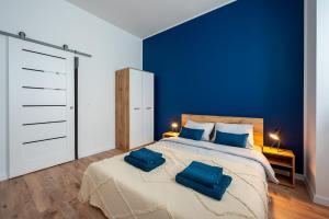 1 dormitorio azul con 1 cama grande y 2 almohadas azules en Atrament, en Przemyśl