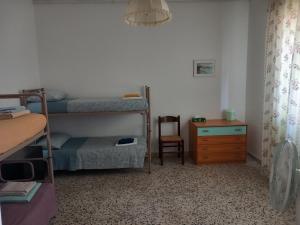 a bedroom with two bunk beds and a chair at Ampio appartamento per 4/6 pers in Cesenatico