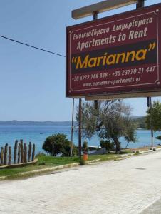 a sign for a marina next to the ocean at Marianna Apartments in Nea Roda