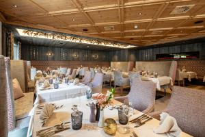 uma sala de jantar com mesas e cadeiras num restaurante em Alpenhotel Ischglerhof em Ischgl