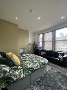 a bedroom with a bed and a couch at Barnet Studios in New Southgate
