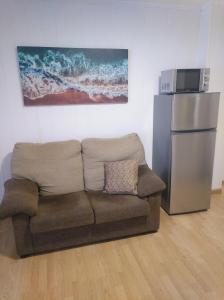 ein Wohnzimmer mit einem Sofa und einem Kühlschrank in der Unterkunft Precioso Estudio in Sada