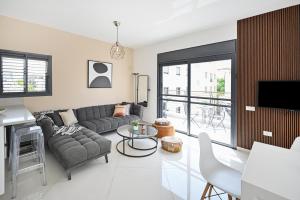 uma sala de estar com um sofá e uma mesa em Modern 3BR Duplex near BograshovBeach by HolyGuest em Tel Aviv