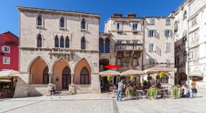 eine Gruppe von Gebäuden mit Tischen und Stühlen in einer Straße in der Unterkunft Apartment Stone in Split