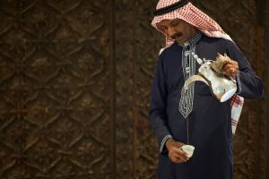 un homme tenant un crâne et une tasse de café dans l'établissement Marina Hotel, à Koweït