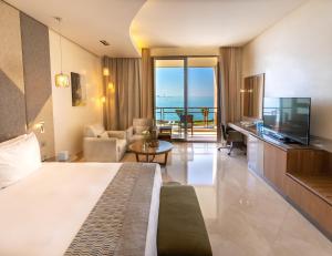 a hotel room with a large bed and a living room at Marina Hotel in Kuwait