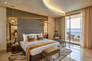 a bedroom with a large bed and a balcony at Marina Hotel in Kuwait