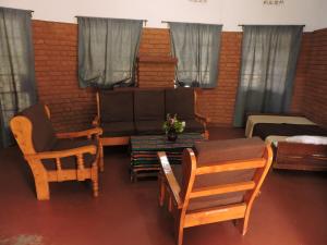 a room with chairs and a table and a bed at Perigrin Rest House in Karatu