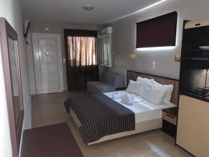 a hotel room with a bed and a couch at Rodolithos Beach Studios in Stavros