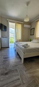 a bedroom with two beds and a large window at Villa Petros in Nydri
