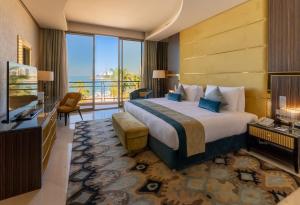 a hotel room with a bed and a television at Marina Hotel in Kuwait