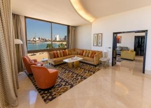 a living room with a couch and chairs and a large window at Marina Hotel in Kuwait +44 photos