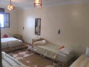 a room with two beds and a mirror at Bayti surf hostel in Agadir