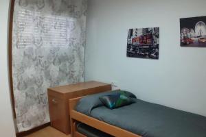 a small bedroom with a bed and posters on the wall at A RIA DE PONTEVEDRA in Pontevedra