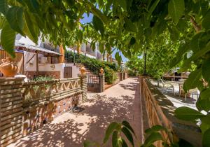 a walkway in front of a house with trees at Apartamentos La Granja in Hinojares