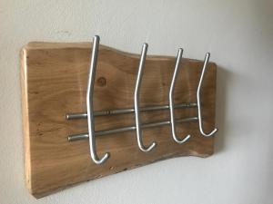a wooden wall mount with metal hooks on a wall at Im alten Büro in Kelberg