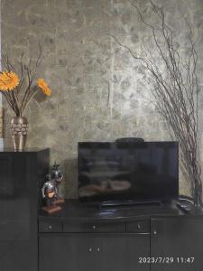 a black entertainment center with a flat screen tv at Fotini's Paradise in Platanidia
