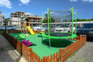 a playground in a parking lot with a green play equipment at Hotel Coral in Eforie Nord