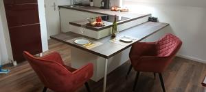 una pequeña cocina con mesa y 2 sillas rojas en Hideaway en Zell am Moos