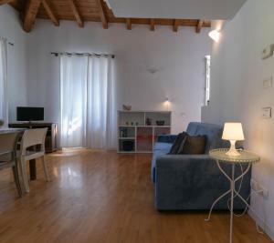 uma sala de estar com um sofá azul e uma mesa em Mamma Ciccia Holiday Home - Casa Azzurra em Mandello del Lario