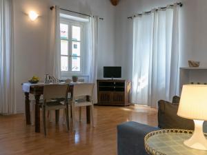 uma sala de estar com uma mesa de jantar e uma televisão em Mamma Ciccia Holiday Home - Casa Azzurra em Mandello del Lario