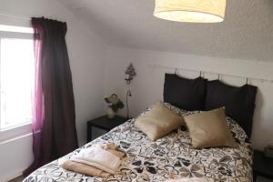 una camera da letto con un letto con cuscini sopra di MappaMundo a Ribamar Altre 95 foto