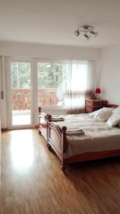 - une chambre avec un lit et une grande fenêtre dans l'établissement Appartement traversant secteur Violettes, à Crans-Montana