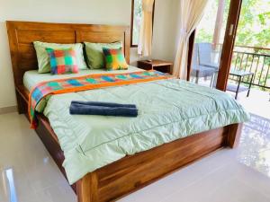 1 dormitorio con 1 cama grande y almohadas coloridas en White House en Ubud