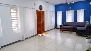 ein Wohnzimmer mit Sofa und blauen Wänden in der Unterkunft WAYANAD OASIS VILLa in Kalpatta