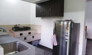 a kitchen with a stainless steel refrigerator and a sink at WAYANAD OASIS VILLa in Kalpetta