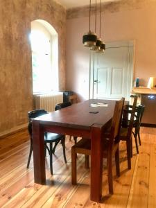 a dining room with a wooden table and chairs at Bahnhof Nebra in Nebra
