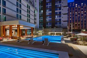 a pool with chairs and tables and buildings at Residence Inn by Marriott Nashville Downtown/Convention Center in Nashville