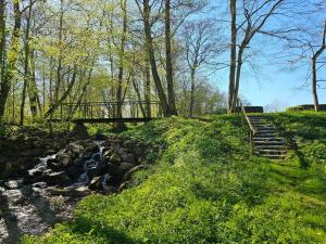 a staircase next to a creek with a bridge at Lärarinnabostad i vacker byskola in Västra Vemmenhög