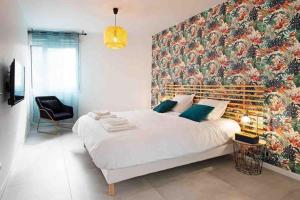 - une chambre avec un grand lit et un grand mur fleuri dans l'établissement appartement avec jaccuzzi 15 min du centre de lyon, à Villeurbanne