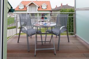 a table and two chairs on a balcony at Illmitzer Weinhof Haider in Illmitz