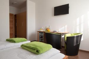 Zimmer mit 2 Betten und einem Schreibtisch mit Monitor in der Unterkunft Illmitzer Weinhof Haider in Illmitz