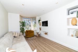 ein weißes Wohnzimmer mit einem Sofa und einem Stuhl in der Unterkunft 4 Bedroom House in Newquay