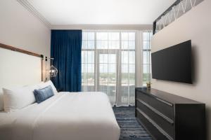 a hotel room with a bed and a flat screen tv at JW Marriott Savannah Plant Riverside District in Savannah