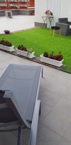 eine Terrasse mit einer Bank und einigen Pflanzen und Gras in der Unterkunft Eolia free parking in Bari